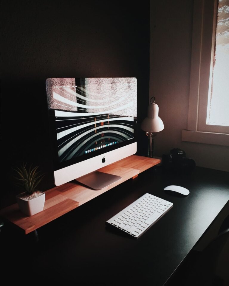 A tidy small desk with cable management and a monitor riser