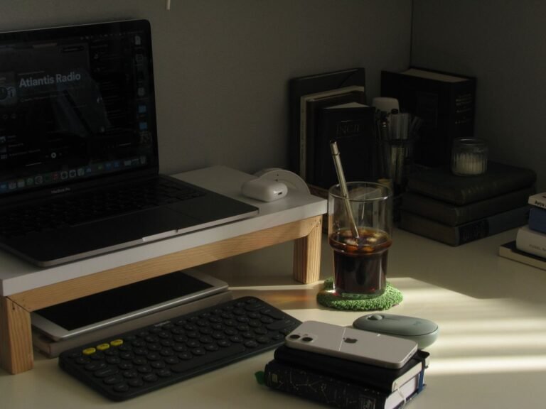 A monitor stand riser lifting a screen on a wood desk