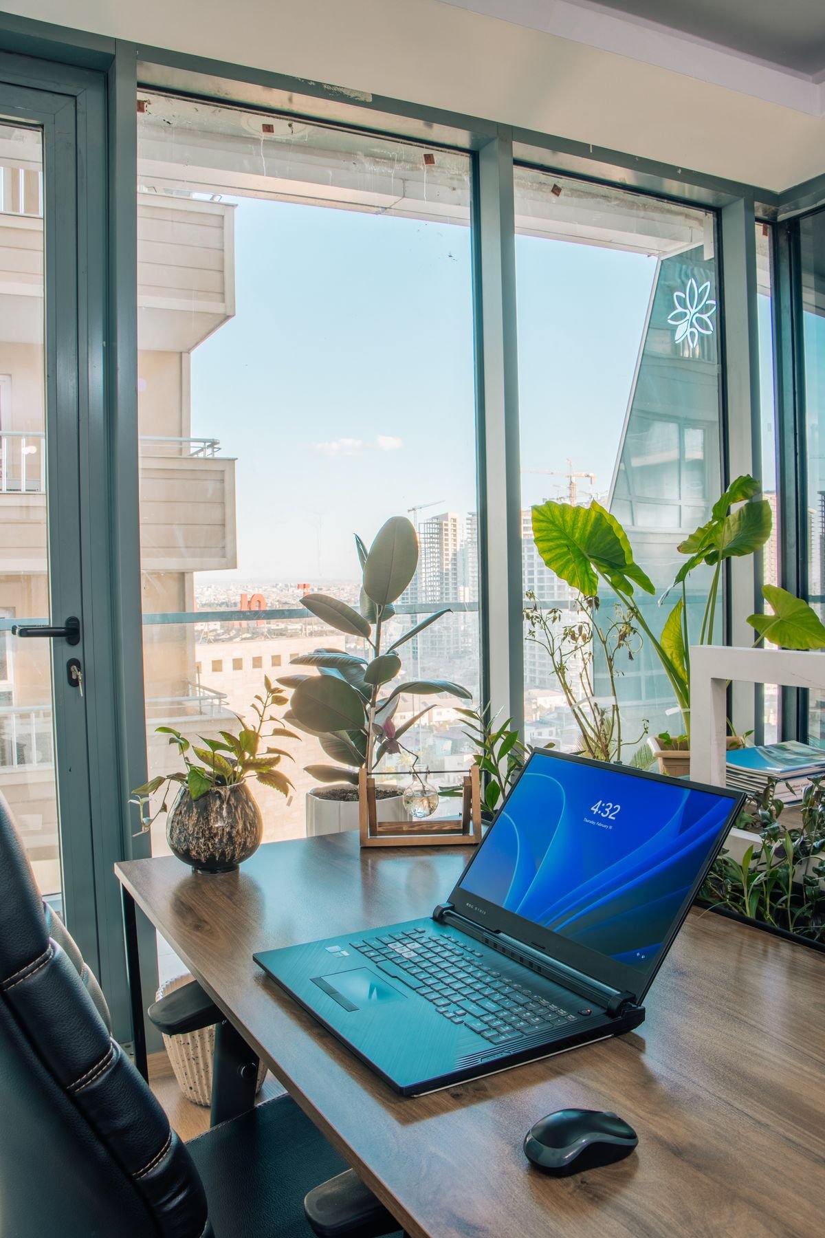 Laptop on a compact desk in a small apartment with a city view