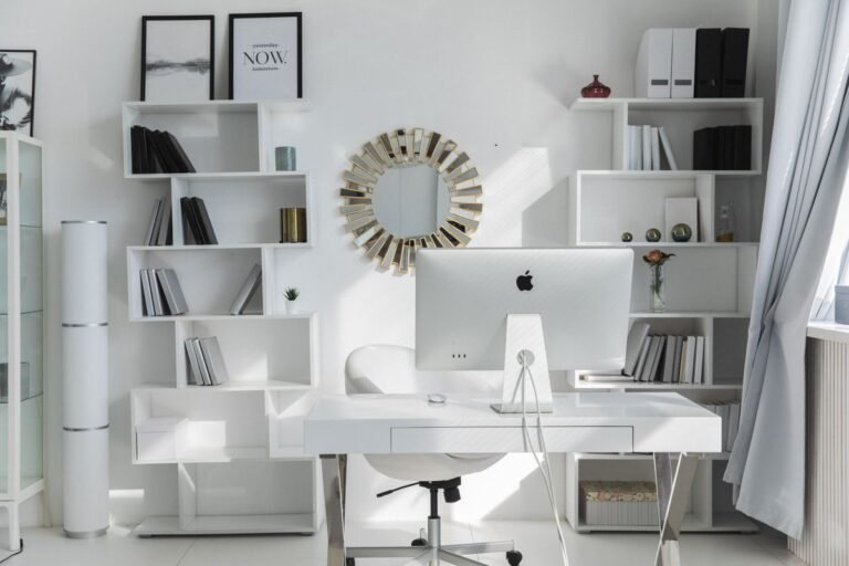 A white wall-mounted shelving desk unit in a bright room