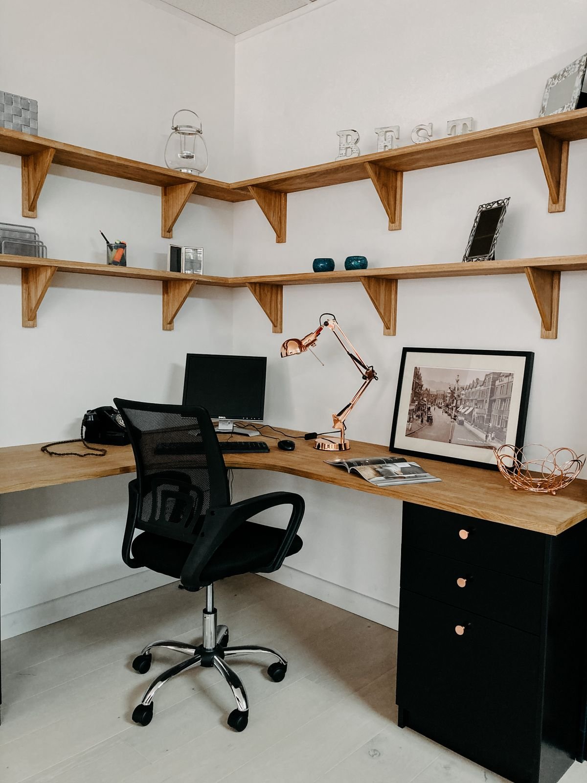 A work corner set up in a studio apartment with a wood desk