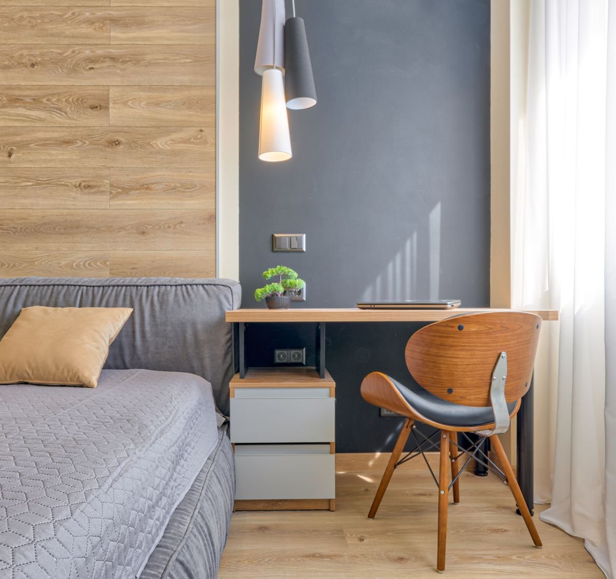 A work-from-bedroom desk setup in a bright bedroom