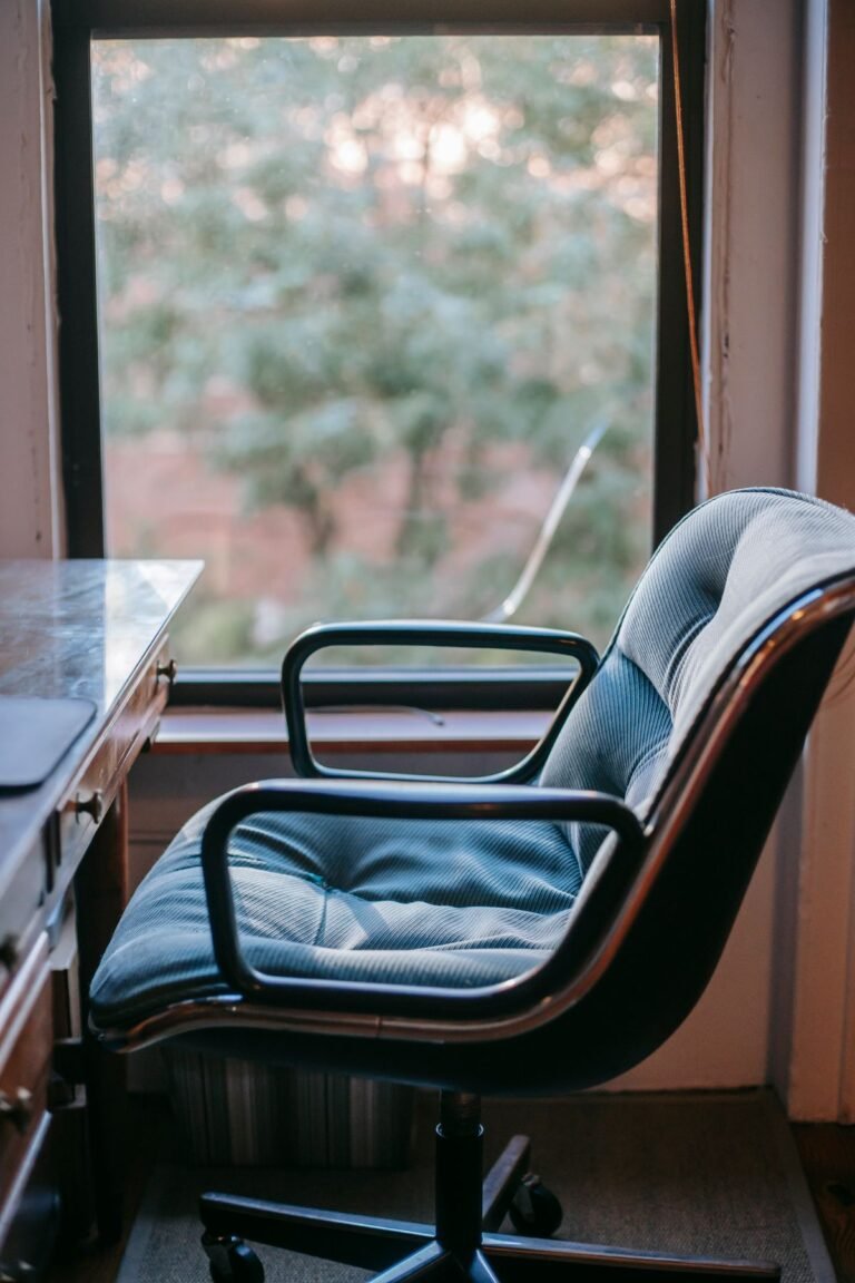 A compact desk chair beside a small desk in a cozy room