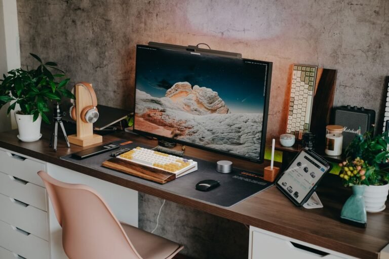 A laptop and an external monitor on a small desk, comparing computer options