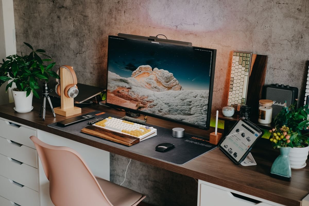 A laptop and an external monitor on a small desk, comparing computer options